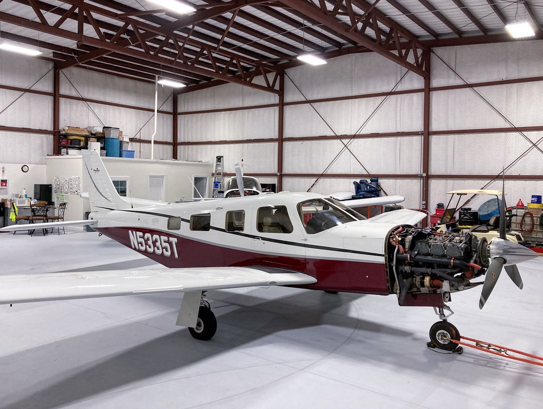 Aircraft mechanic performing annual inspection in a well-lit hangar