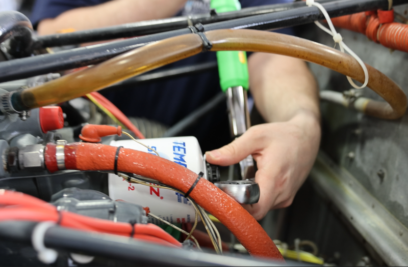 Certified maintenance team inspecting and repairing light jet at manufacturer service center