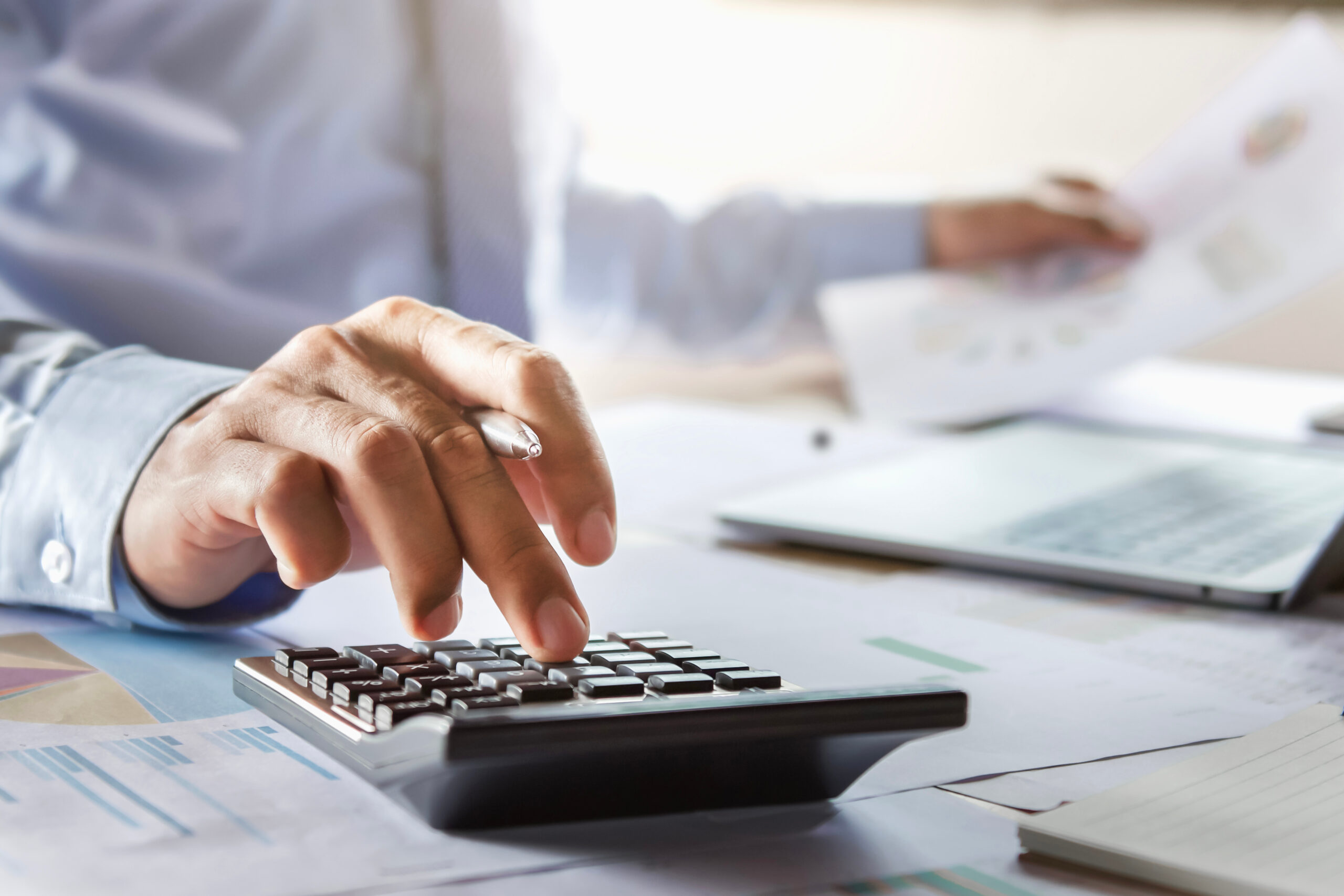 accountant working on desk using calculator for calculate financ Aircraft Financing