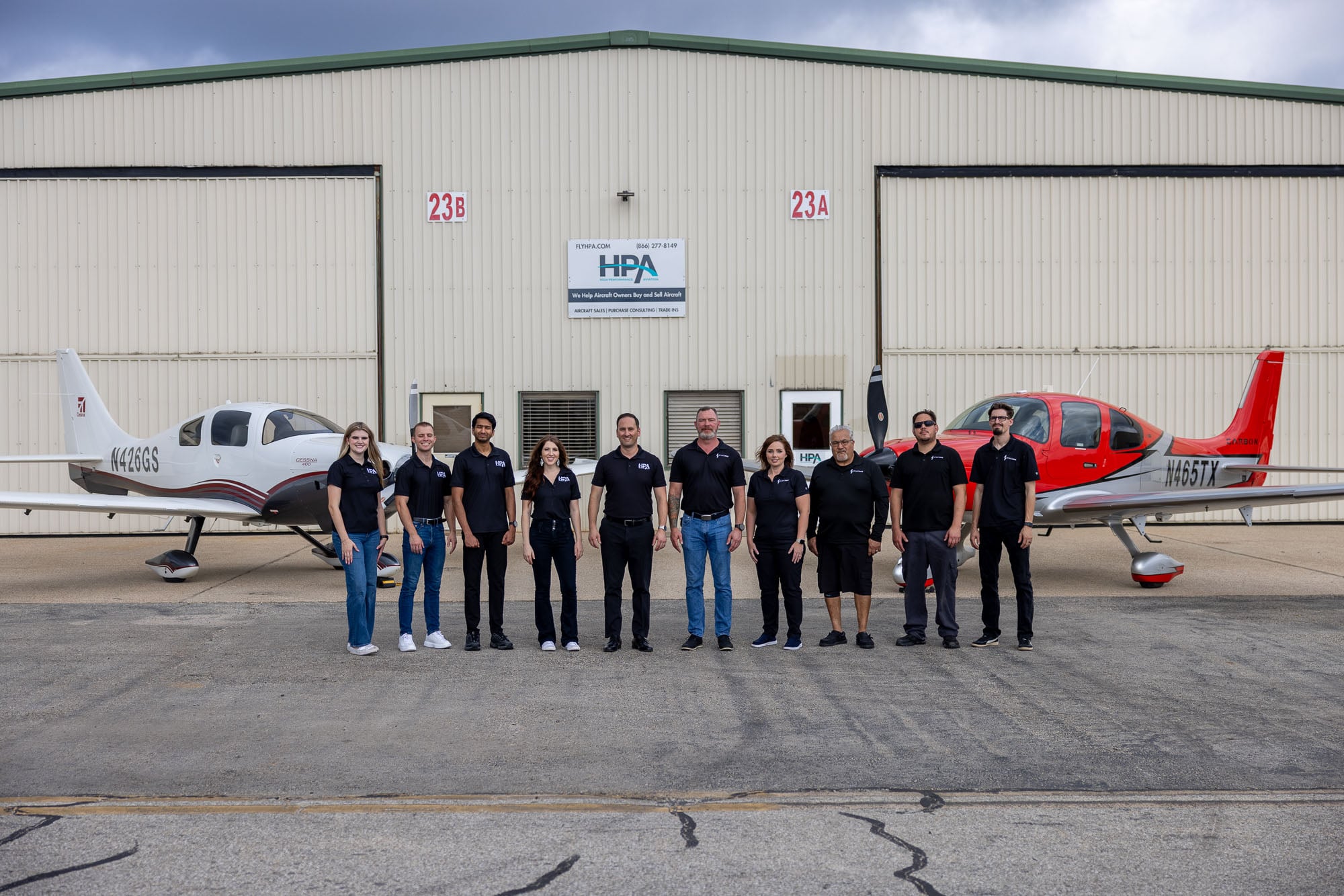 2026.08.08-11.26-flyhpa-6a77bb322a5b7 High Performance Aviation team in front of the Conroe hangar with two aircraft