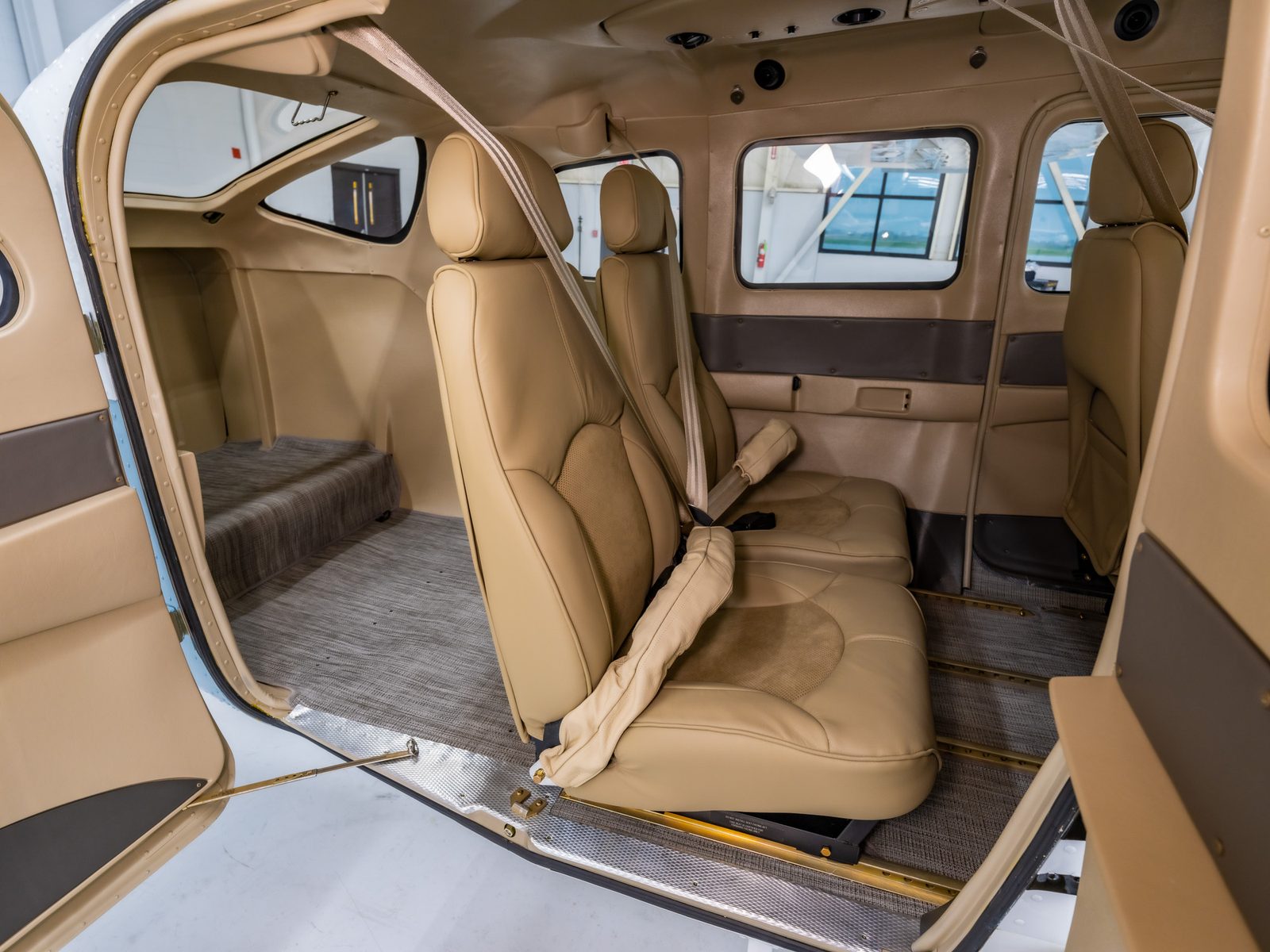 Cessna 206 rear cabin with tan leather seats, seen through the cargo door